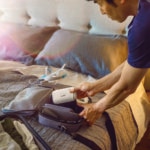 A man packing his AirMini in an overnight bag in preparation for a trip away.