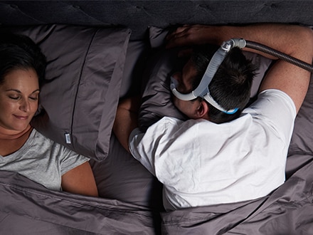A patient wearing a ResMed AirFit N30i nasal mask while sleeping on their front.