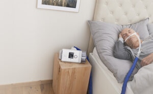 A man sleeping in bed while receiving home high-flow therapy treatment