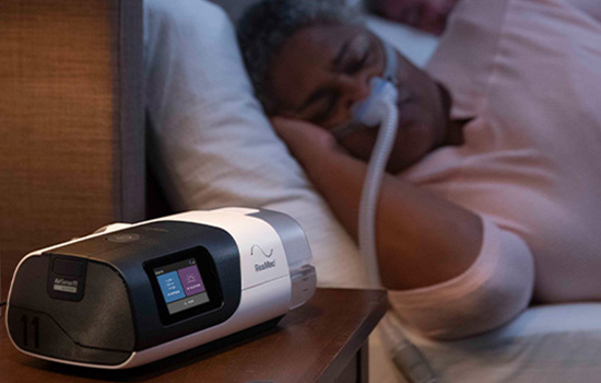 Woman sleeping comfortably with ResMed CPAP machine