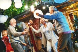 A group of six people of different ages and genders dancing, smiling and enjoying life